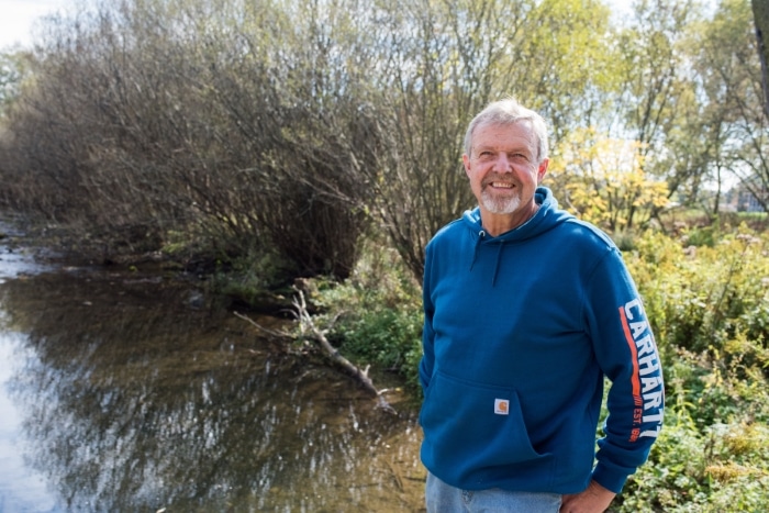 smiling dairy farmer near a creek