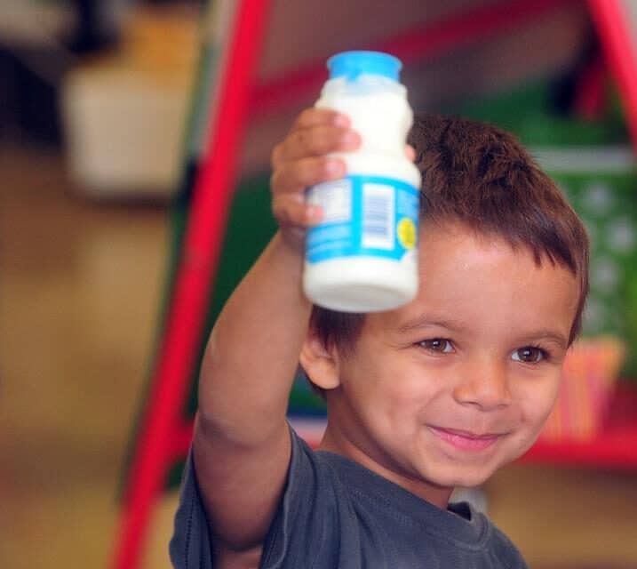 kid holding a bottle of milk