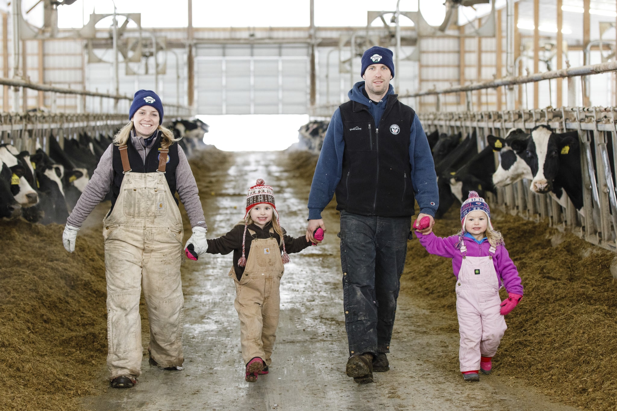 family of dairy farmers in the barn