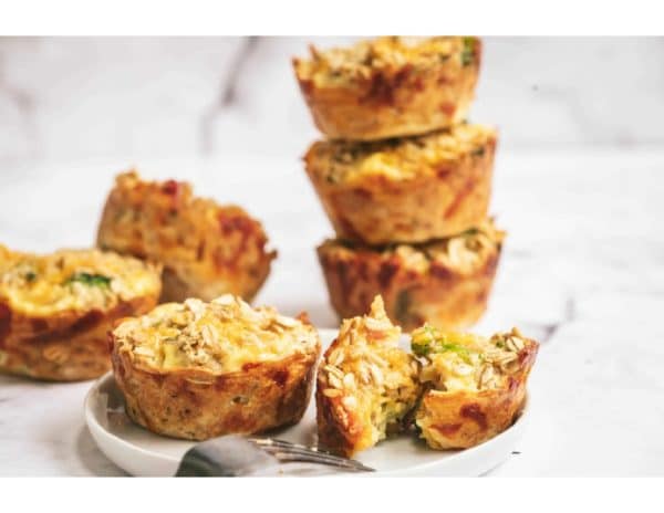 Cheesy baked oatmeal treats served and stacked on a plate.