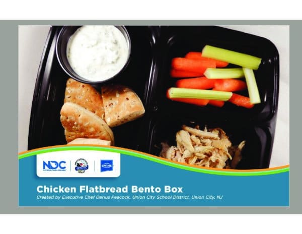 A picture of a chicken flatbread bento box, filled with different foods and snacks.