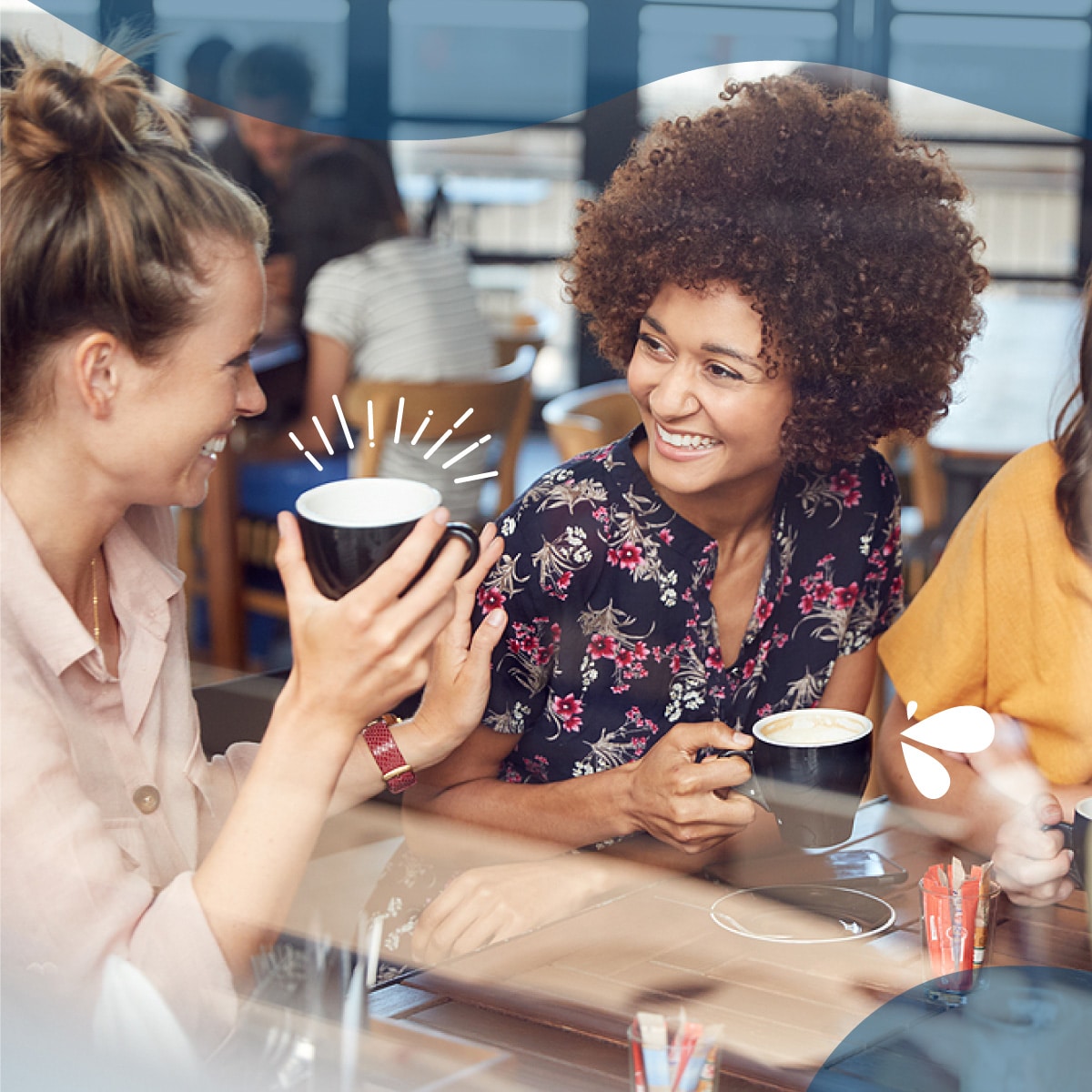 Two women laughing while drinking coffee