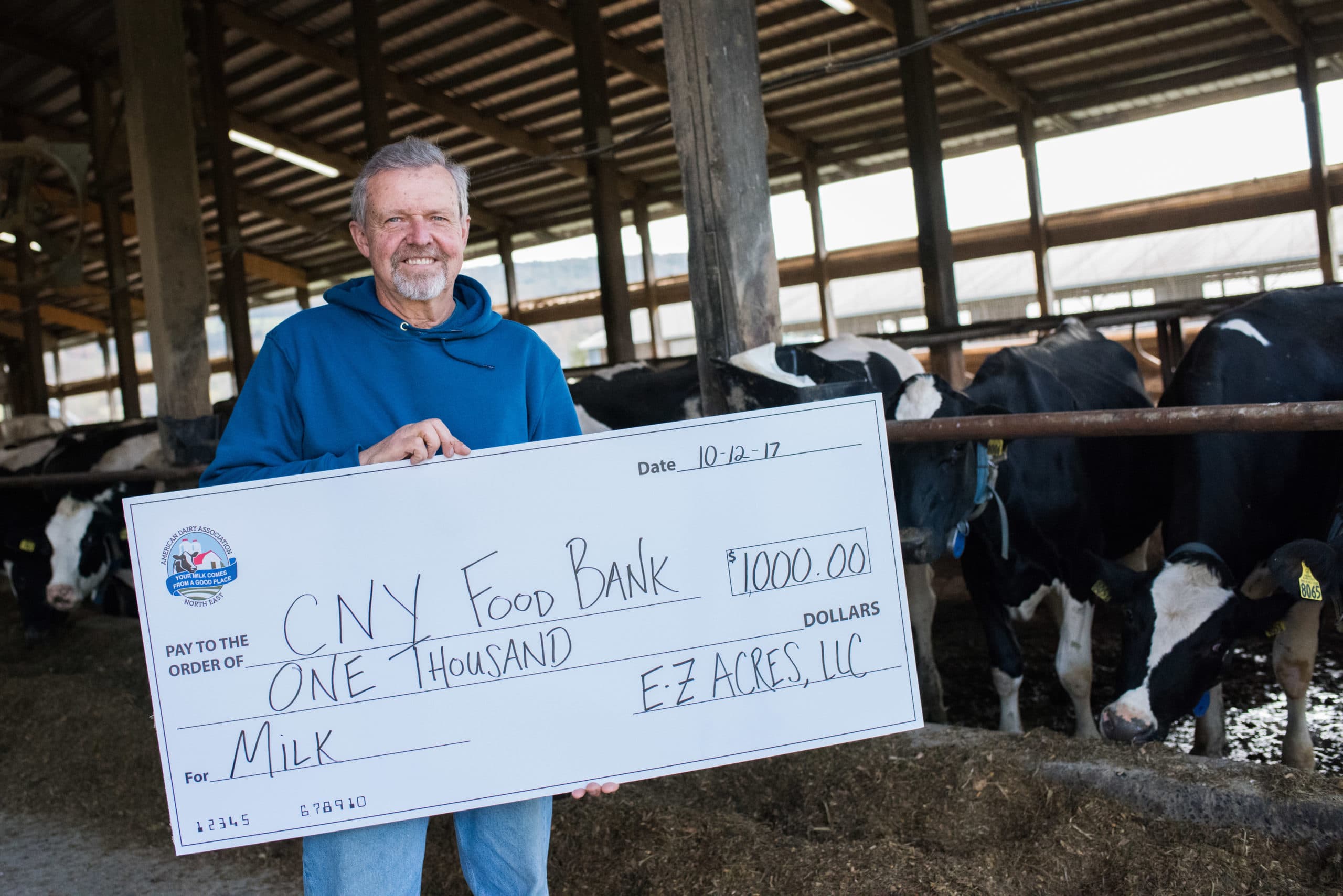 Man holding a large check with cows