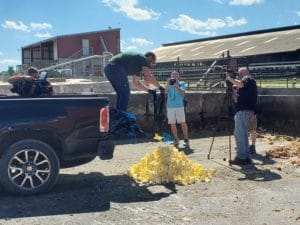 Men dumping butter from a pickup truck