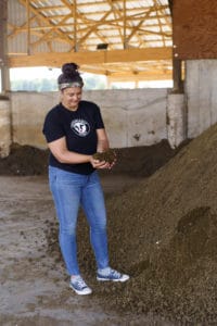 Girl collecting cow manure