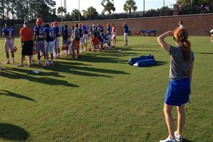 Woman watching football players practice