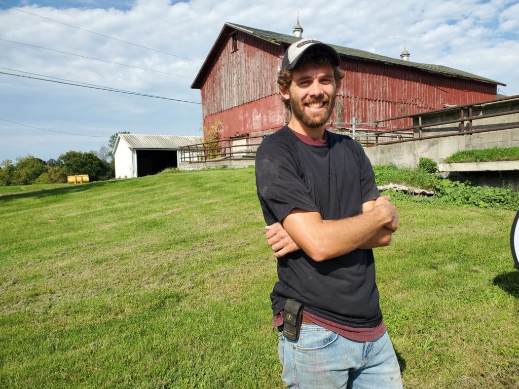 farmer with his barn in the background