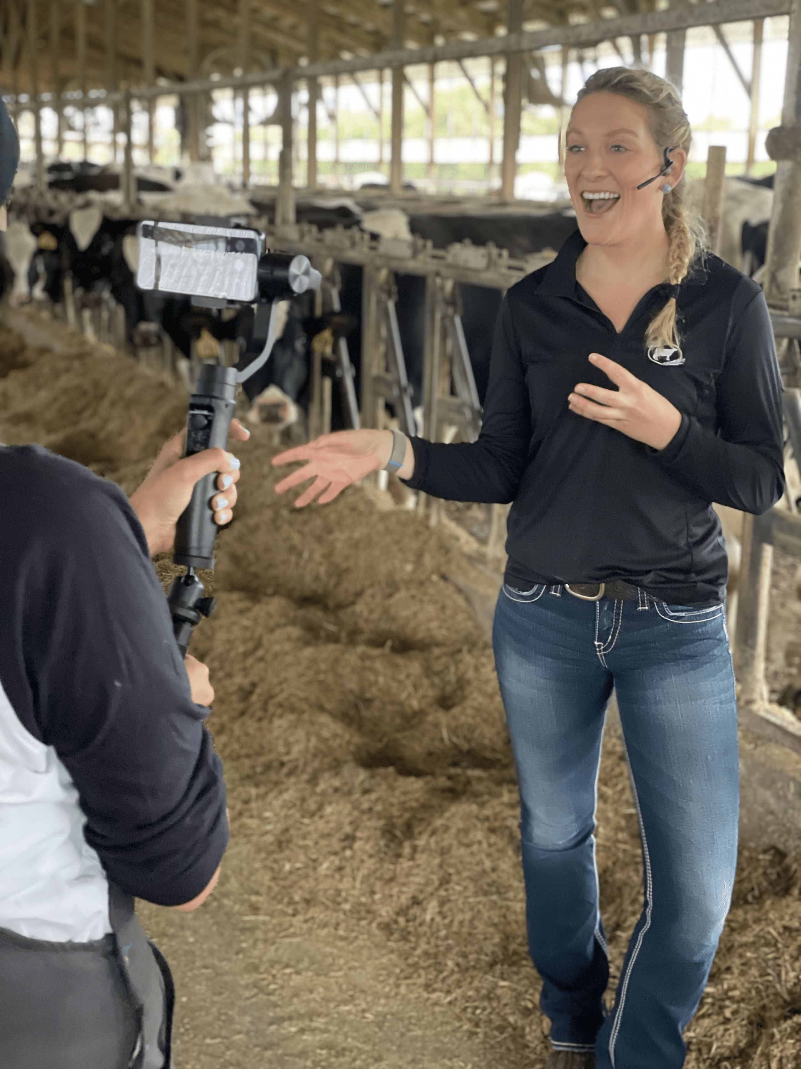 Woman being filmed in front of a cow pen