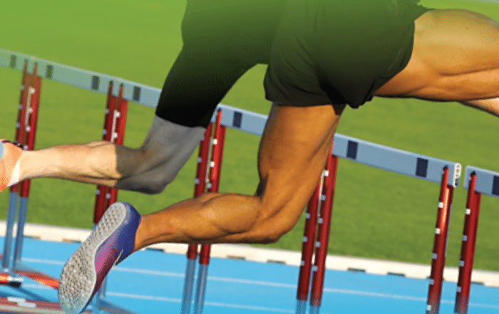 two sets of athletics legs doing track and field hurdles