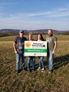 3. 2021 DFT sign. Hemsarth.Bruce Brenda Cheryl Greg Family holding a Hemsarth Dairy sign