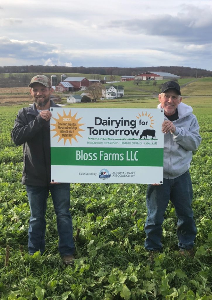 Two winning farmers holding a sign