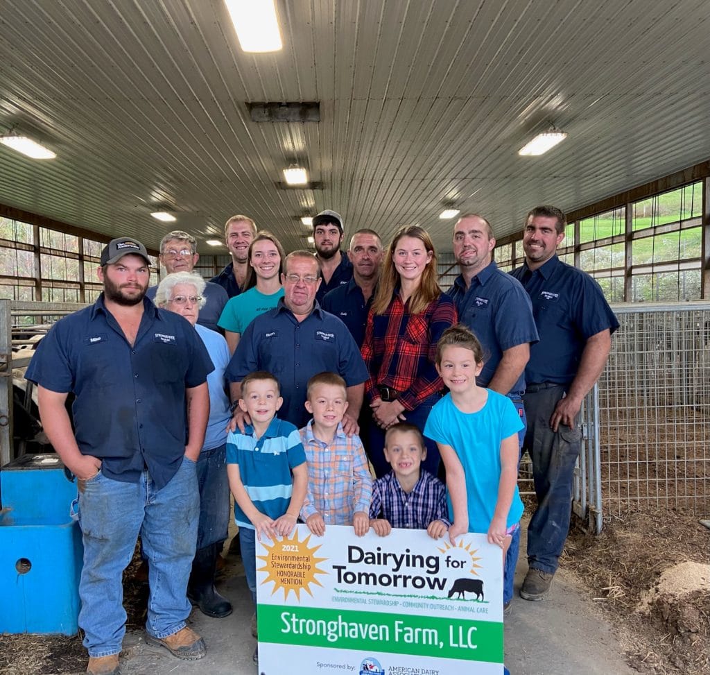 Large family of winning farmers holding a sign