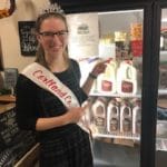 Dairy princess pointing at a milk display