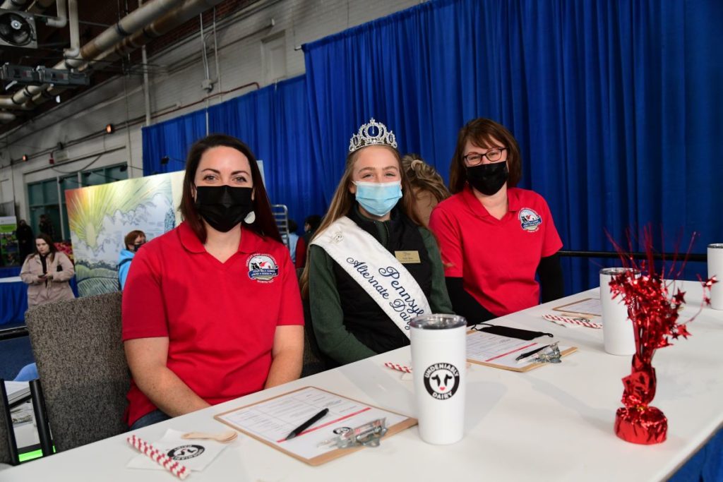 Two volunteers sitting on either side of a Dairy Princess