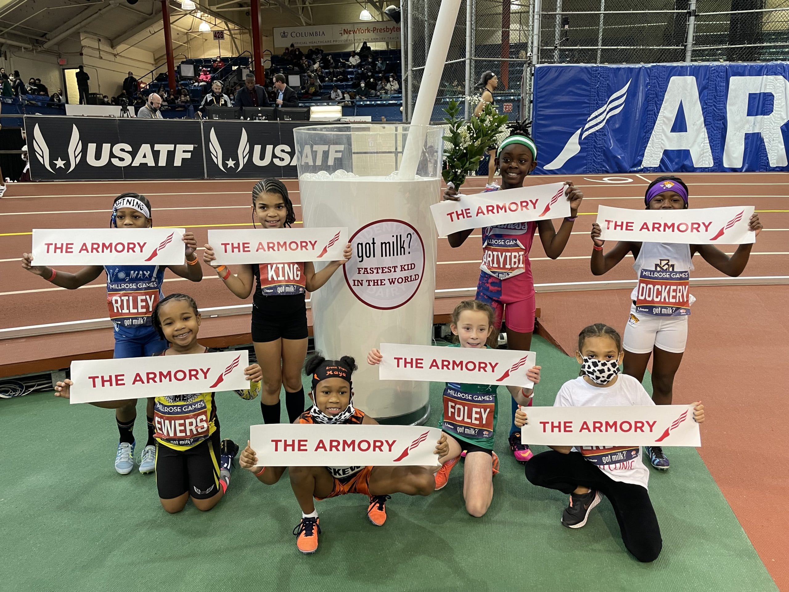 Little kids holding signs that say The Armory