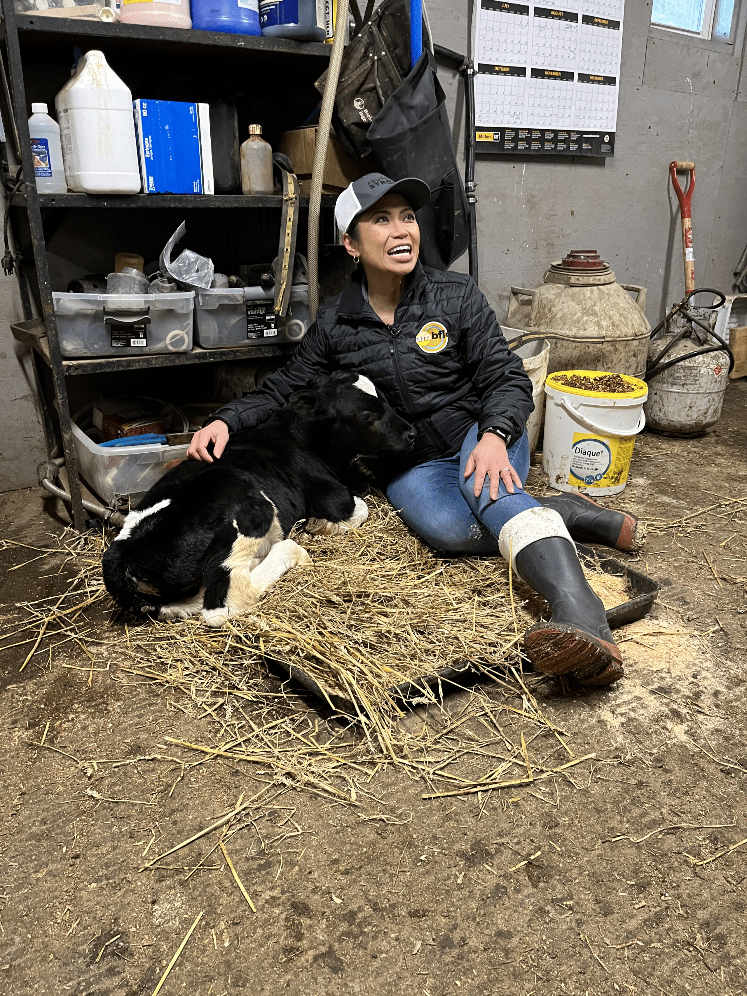 Woman smiling while petting a calf
