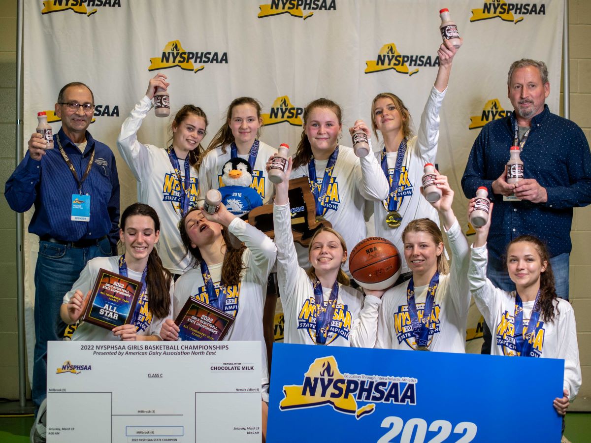 Winning girls sports team holding a trophy and milk