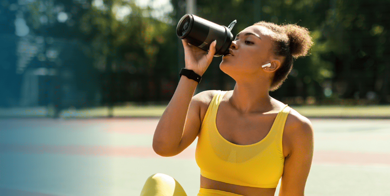 Woman drinking water from a water bottle after a workout