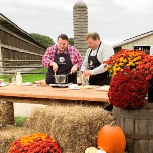 Farmer owner and chef cook pasta sauce on wooden table, celebrating National Farmers Day.