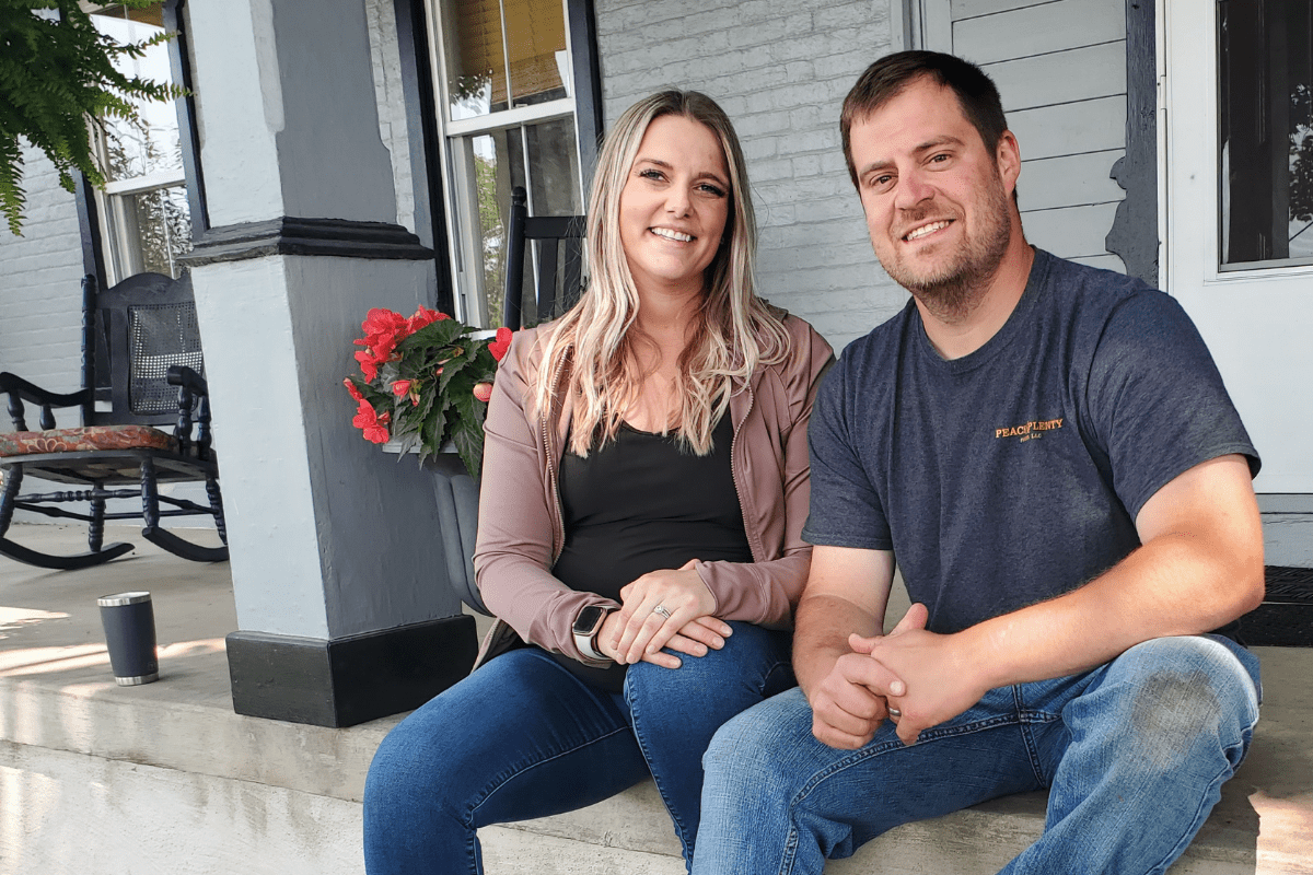 A dairy farmer couple sitting on the porch.