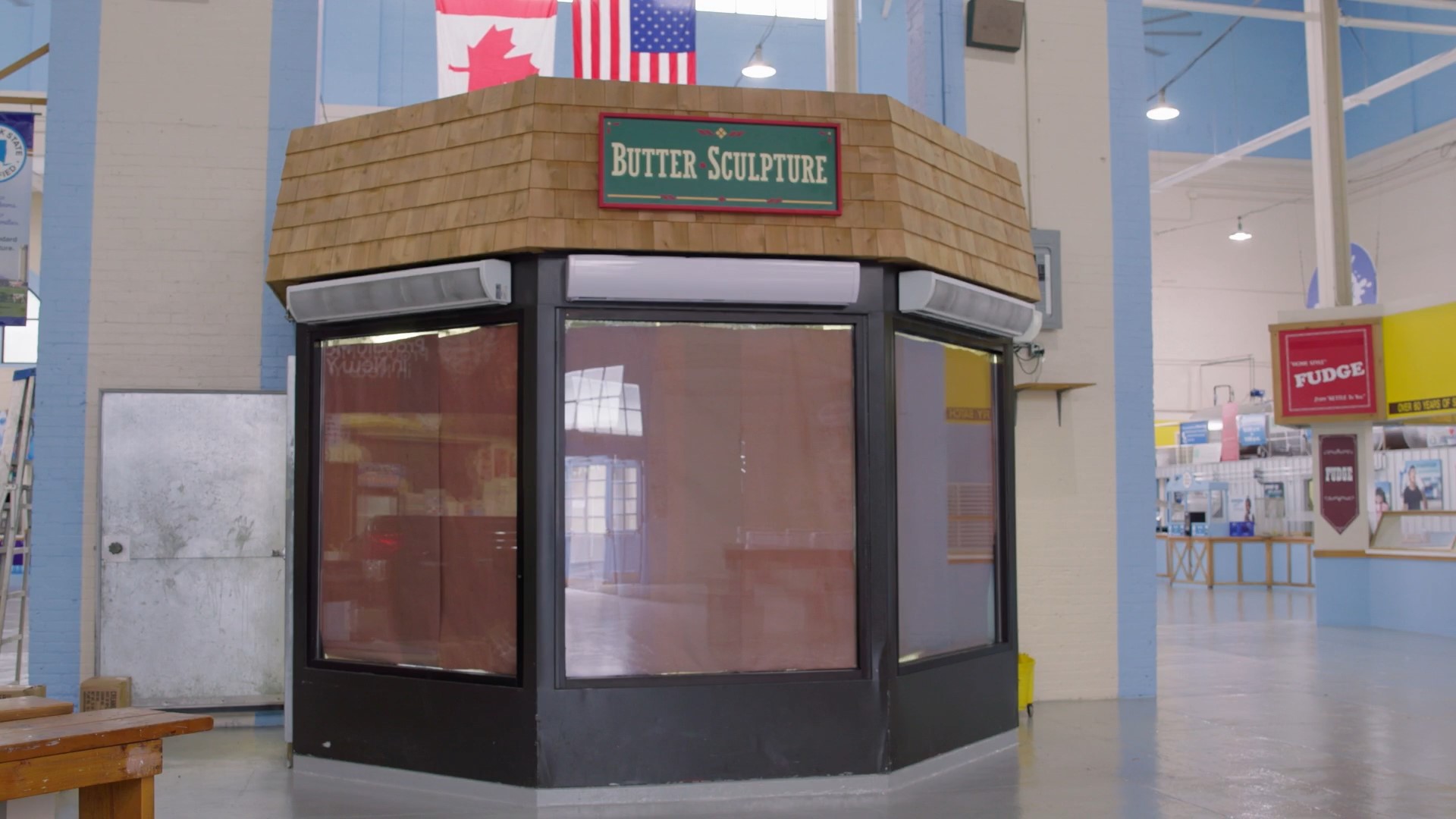 The outside of a room that has a butter sculpture inside.